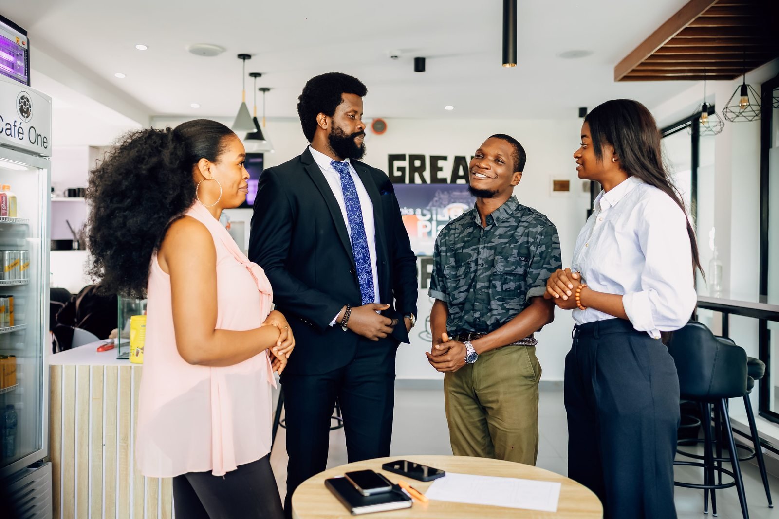Des professionnels discutent debout dans un espace de travail à Lagos.